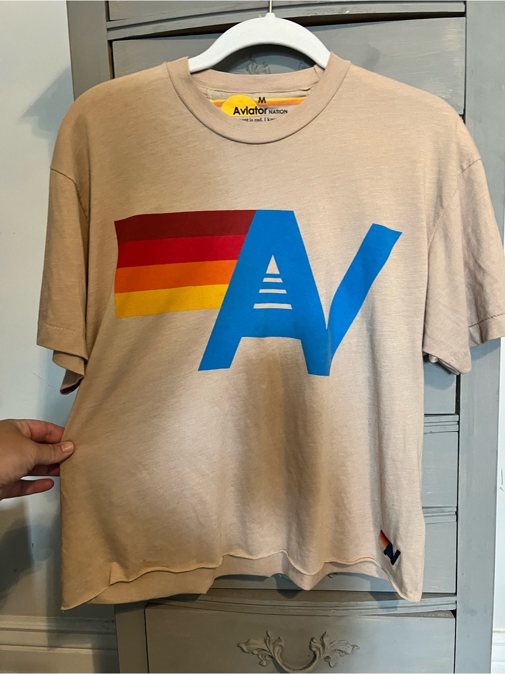 Aviator Nation Beige Tee with Blue 'AV' and Red-Orange-Yellow Stripe